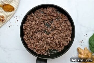 Browned ground beef in skillet after being cooked through.