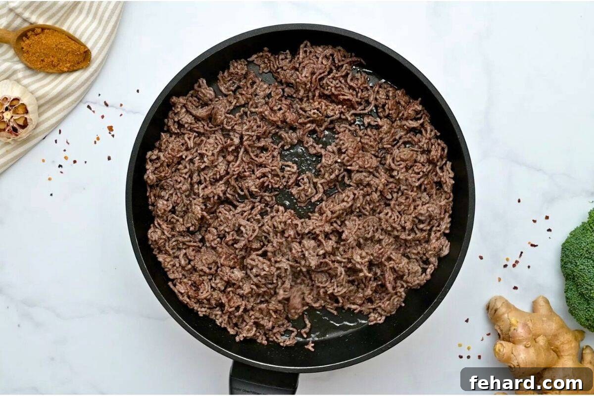 Browned ground beef in skillet after being cooked through.