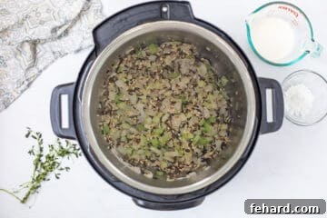 Onion, celery and wild rice sauteed inside inner pot to begin Instant Pot Wild Rice Soup.