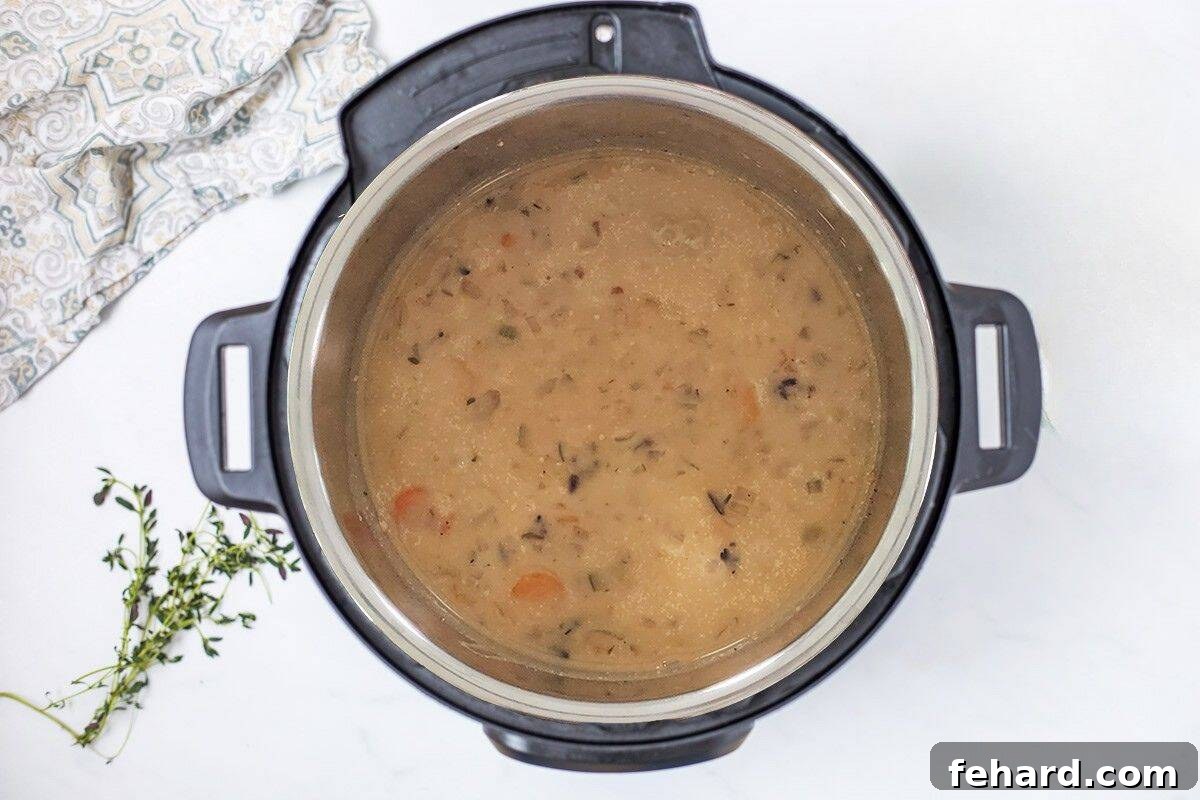 Creamy wild rice soup inside the Instant Pot, after being thickened with half and half and cornstarch, achieving its rich and velvety texture.