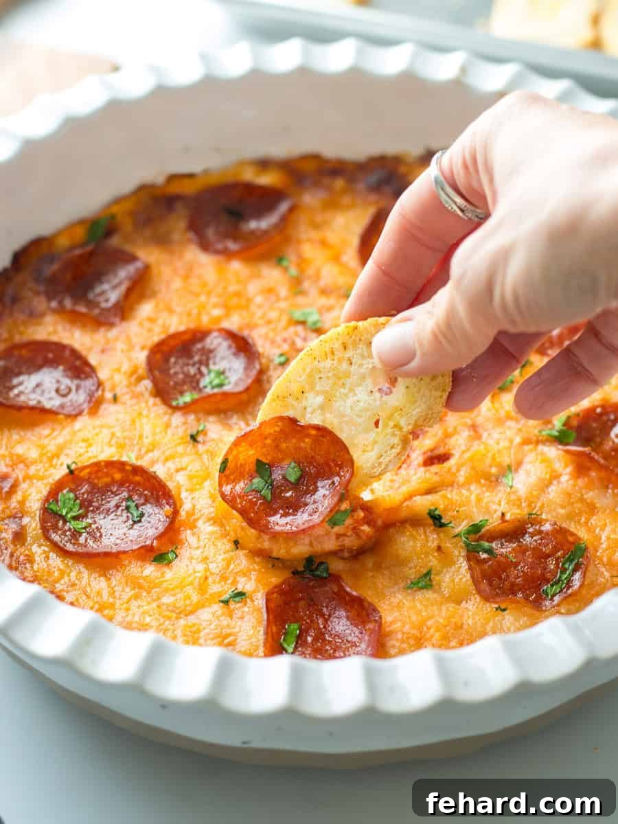 Best Baked Pizza Dip Recipe Golden brown baked pizza dip with melted cheese and pepperoni, served with toasted crostini for dipping. A perfect appetizer for parties.