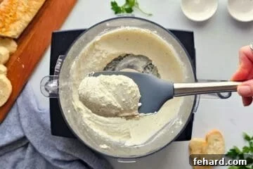 Cheesy Pizza Dip 3 Spatula showing blended base made in food processor with seasonings, cottage cheese, and cream cheese.