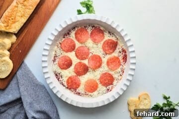 Cheesy Pizza Dip 4 Cream cheese and cottage cheese based spread out in shallow layer in pie plate topped with pizza sauce, shredded mozzarella cheese, and sliced pepperoni.