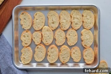 Cheesy Pizza Dip 6 Sliced baguette on baking tray after being lightly toasted to serve with pizza dip.
