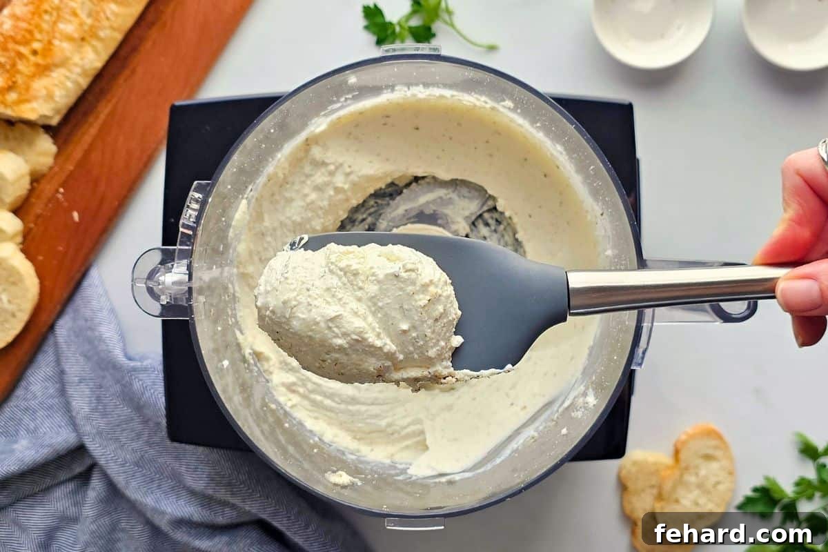 Pizza Dip with Cream Cheese Base Spatula showcasing the perfectly blended, smooth cream cheese and cottage cheese base, prepared in a food processor with herbs and spices.