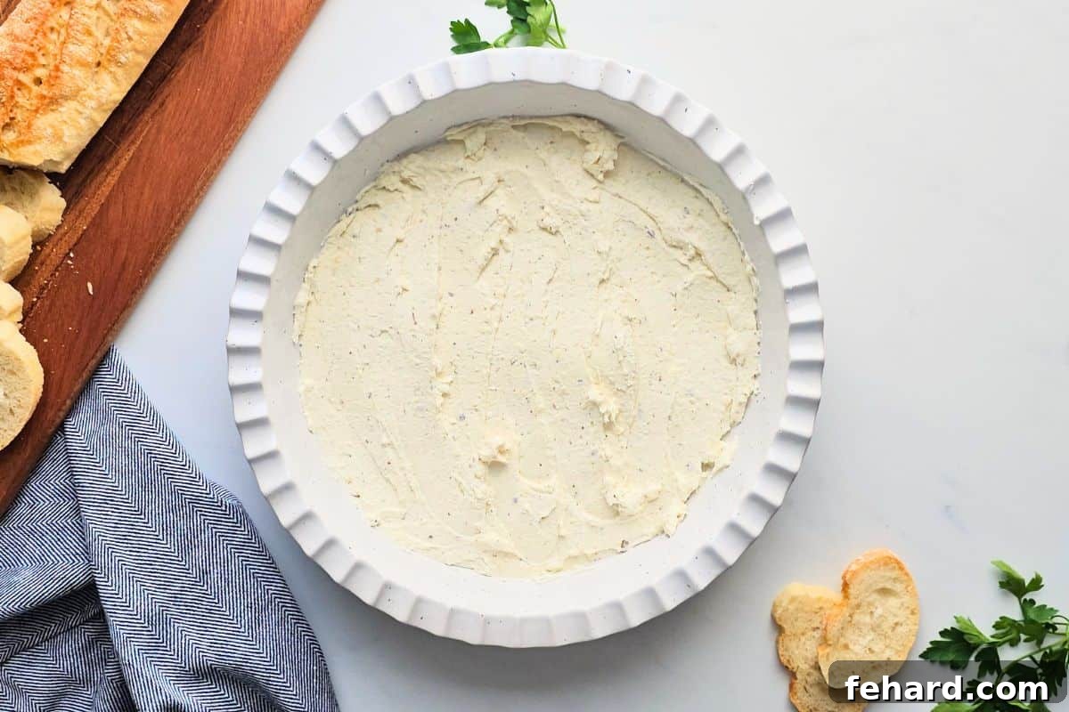 Cottage Cheese Pizza Dip Base The creamy, smooth cottage cheese and cream cheese base spread out in a shallow pie plate, ready for the next layers.