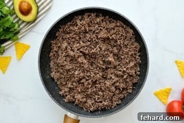 Cooked and crumbled ground beef in skillet for base of taco casserole.