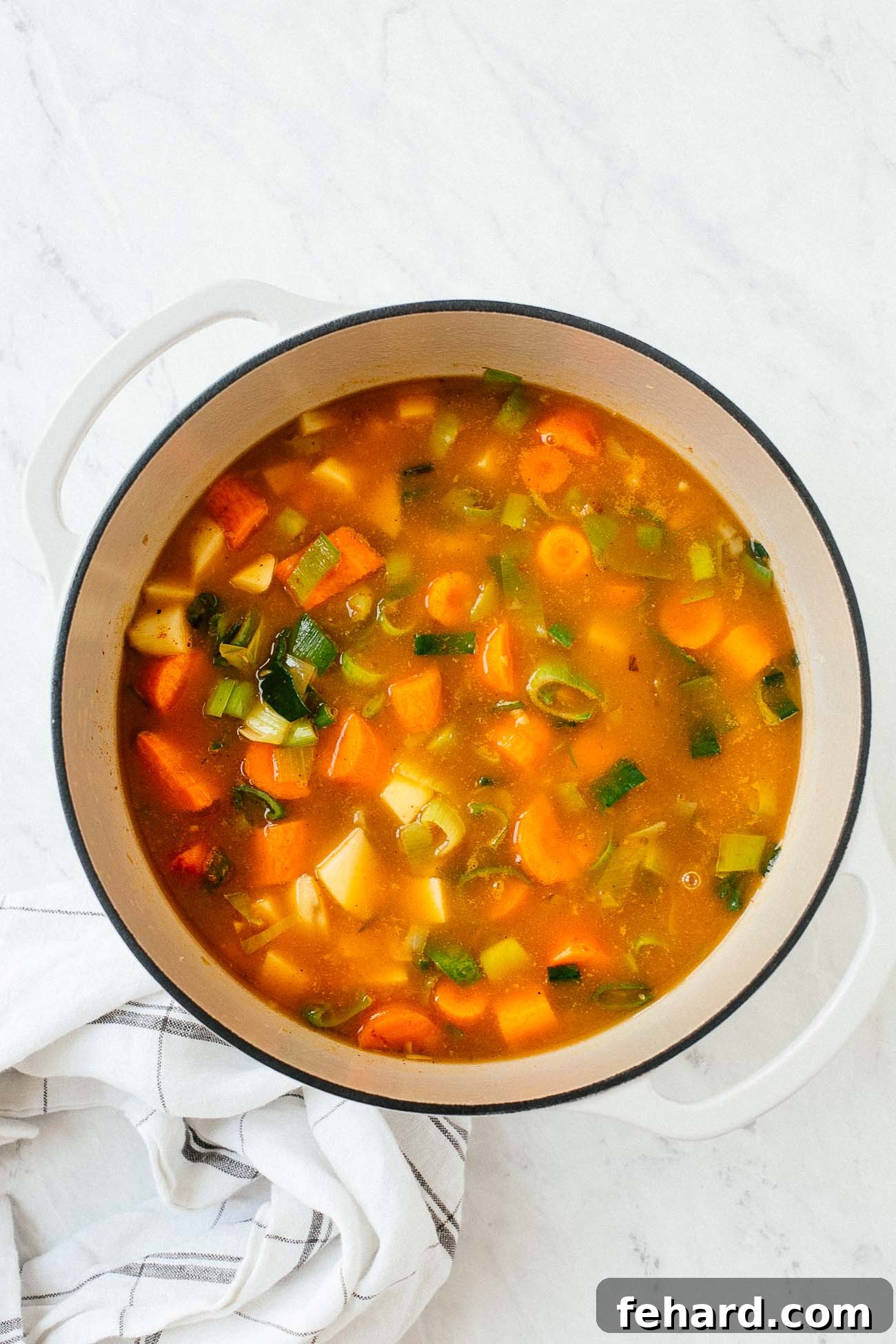 Comforting Carrot Leek Soup 6 A dutch oven with vegetable soup inside.