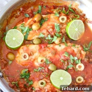 Skillet with Fish Veracruz topped with fresh lime slices and cilantro.