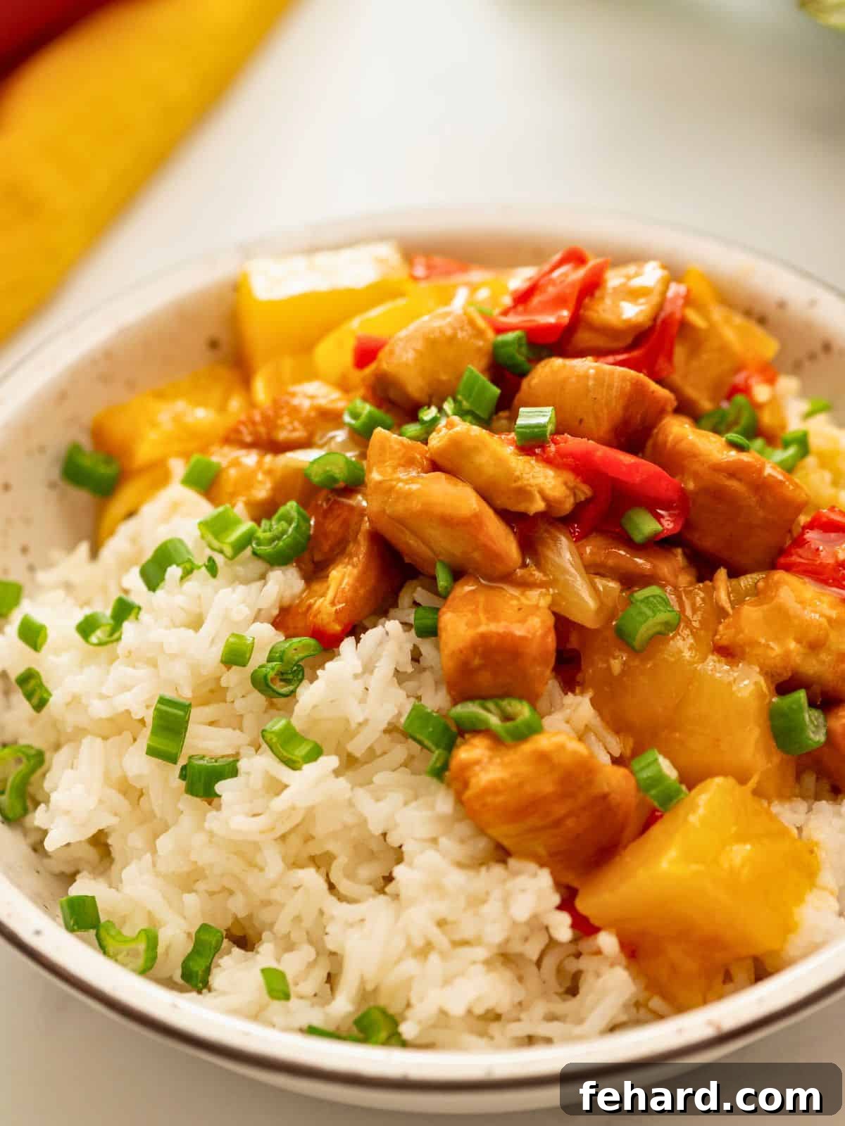 A vibrant plate of Instant Pot Sweet and Sour Chicken served with perfectly cooked Instant Pot white rice, garnished with fresh green onions.