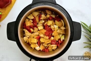 Chicken, pineapple, peppers, and onions layered together with homemade sweet and sour sauce inside instant Pot.