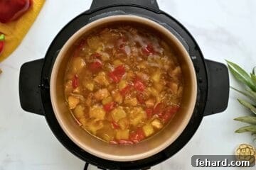 Pressure Cooked Sweet and Sour Chicken with peppers and pineapple inside inner pot.