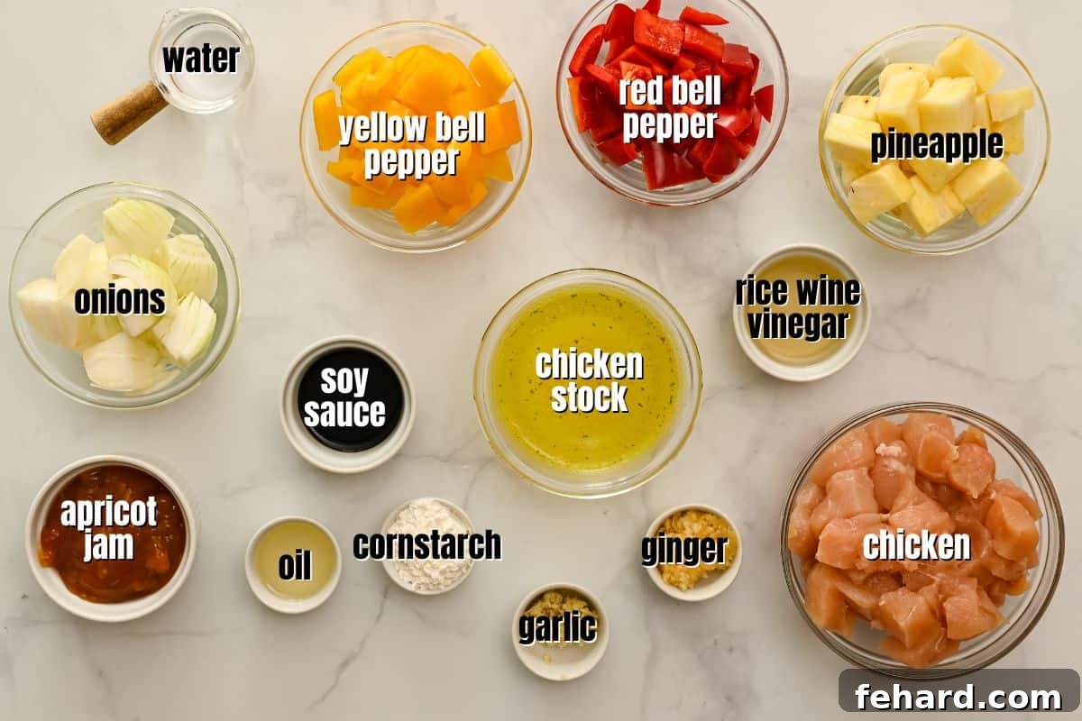 A selection of fresh ingredients for Sweet and Sour Chicken including chicken, bell peppers, pineapple, ginger, garlic, and apricot jam, neatly arranged on a counter.