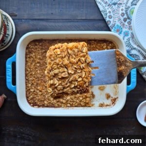 Spatula lifting out slice of sweet potato baked oatmeal from blue staub baking dish.