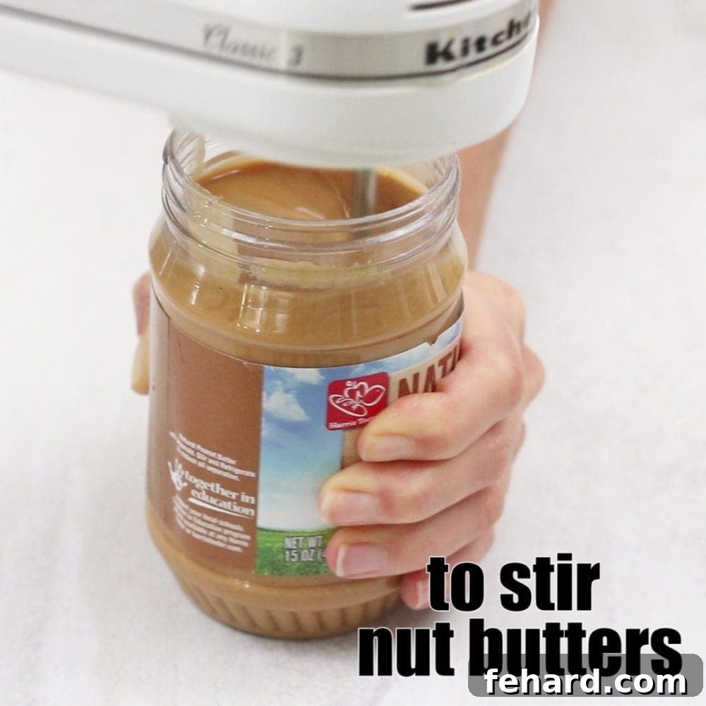 How to Stir Peanut Butter Hand Held Mixer Stirring Peanut Butter with title text that reads to stir nut butters.