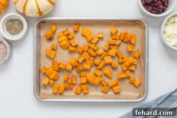Roasted cubed butternut squash on baking sheet lined with parchment paper.