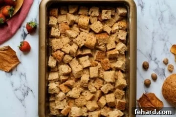 Bread cubes soaked in maple egg custard in butter baking dish.