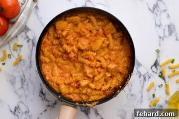 Cooked pasta with creamy Cajun chicken sauce.