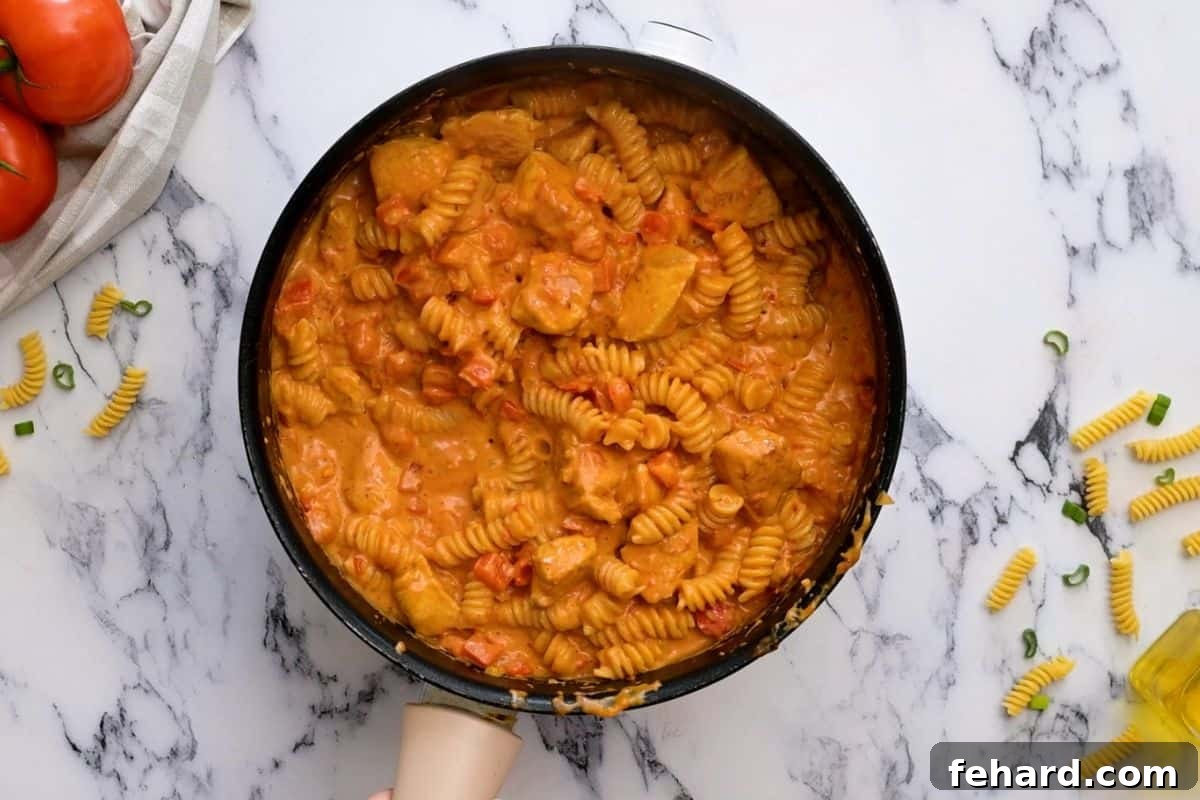 The finished one-pot creamy Cajun Chicken Pasta, rich and velvety, with tender pasta and chicken fully coated in the decadent sauce, ready to be garnished.