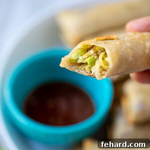 Crispy Egg Roll with a bite taken out, revealing the vibrant vegetable filling.