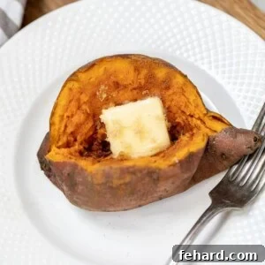 Instant Pot Sweet Potato on white plate topped with pat of butter, showing its fluffy texture.