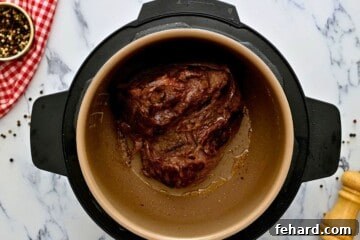 Seasoned chuck roast after being seared inside inner pot.