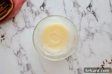 Cream cheese frosting for cinnamon roll in mixing bowl.