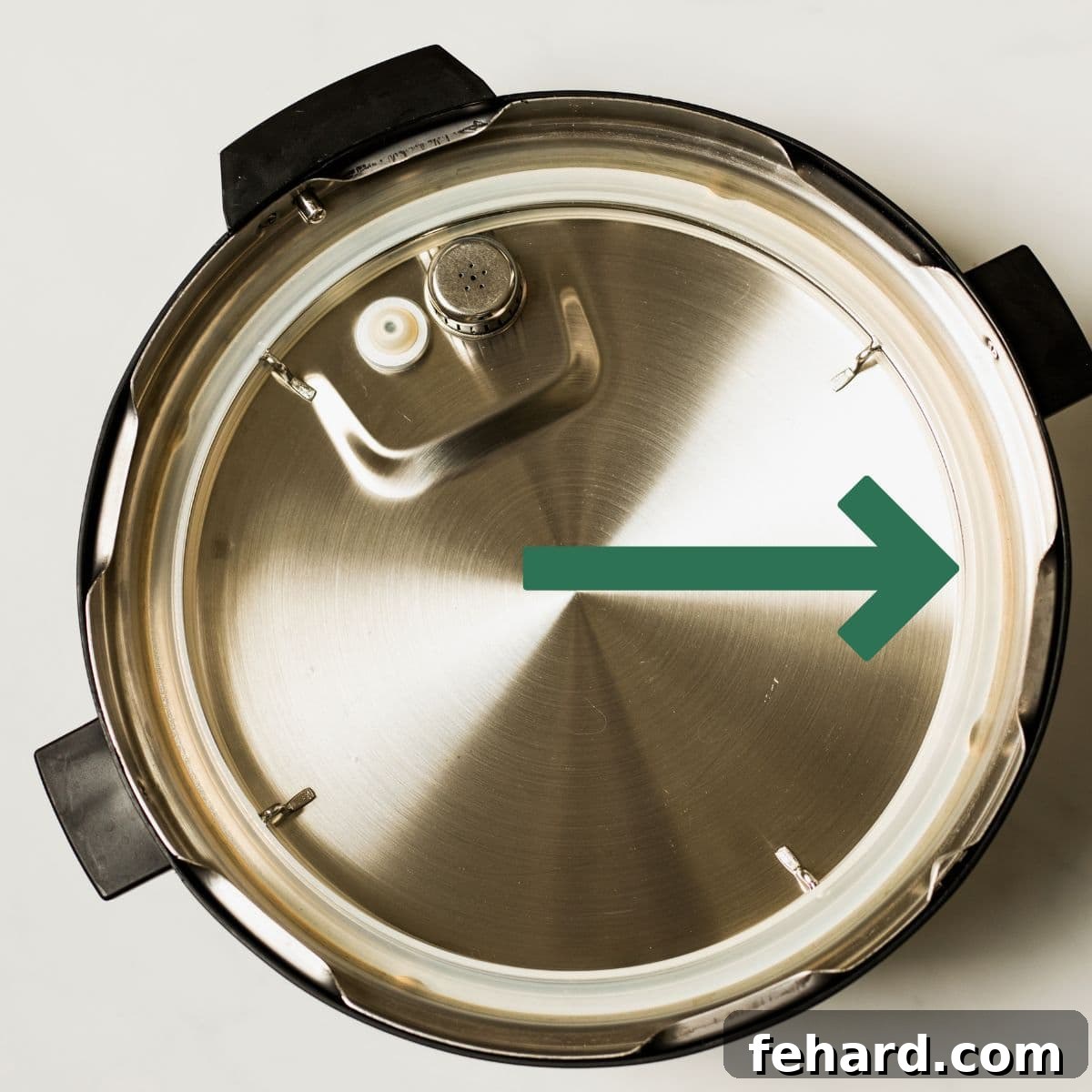 Instant Pot Lid upside down on counter with arrow pointing to sealing ring.
