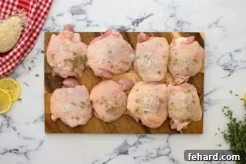 8 chicken thighs seasoned with salt and pepper on wooden cutting board.