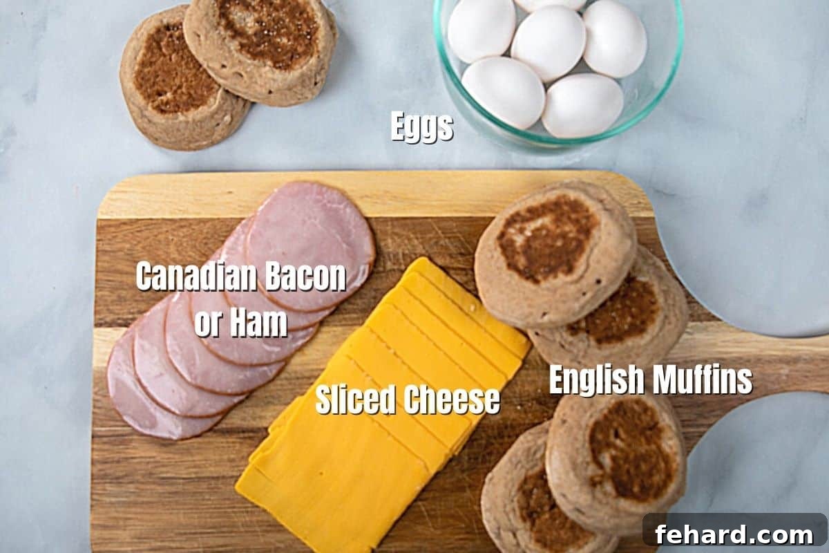 A vibrant display of fresh ingredients for homemade egg mcmuffins, including English muffins, eggs, various cheeses, and Canadian bacon, neatly arranged on a kitchen counter.