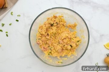 Tuna Patty mixture made with lemon and green onions in large mixing bowl.