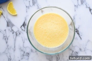 Wet ingredients for whole wheat pancake batter, including buttermilk, eggs, and melted butter, mixed in a separate bowl.