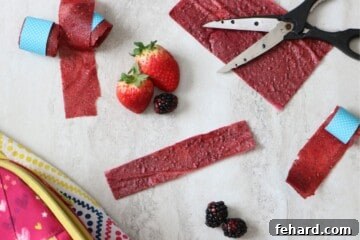 Real Fruit Delights: DIY Chewy Strips 6 Fruit leather cut into strips next to fresh fruit and lunchbox.