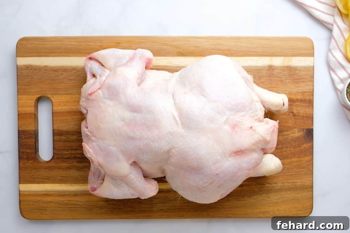 Raw chicken sitting on cutting board.