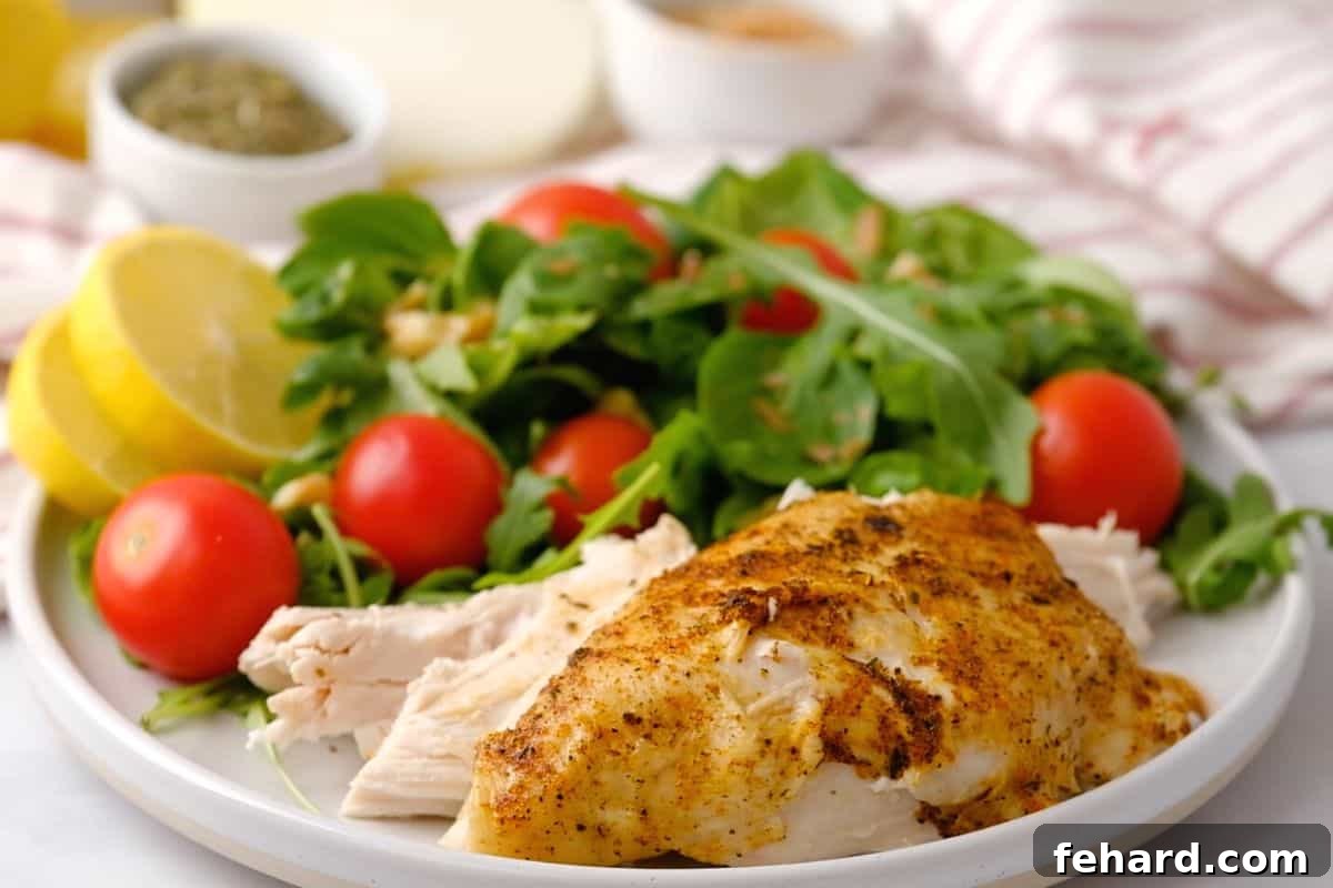 Chicken on a plate next to salad.