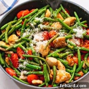 Skillet with chicken, tomatoes, green beans, and a flavorful sauce.