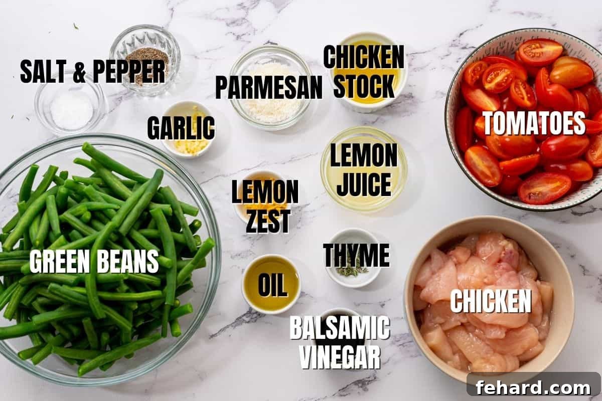 Green Beans and Chicken Ingredients Fresh ingredients laid out on a white countertop, including raw chicken, green beans, cherry tomatoes, lemon, garlic, and herbs, ready for the skillet recipe.