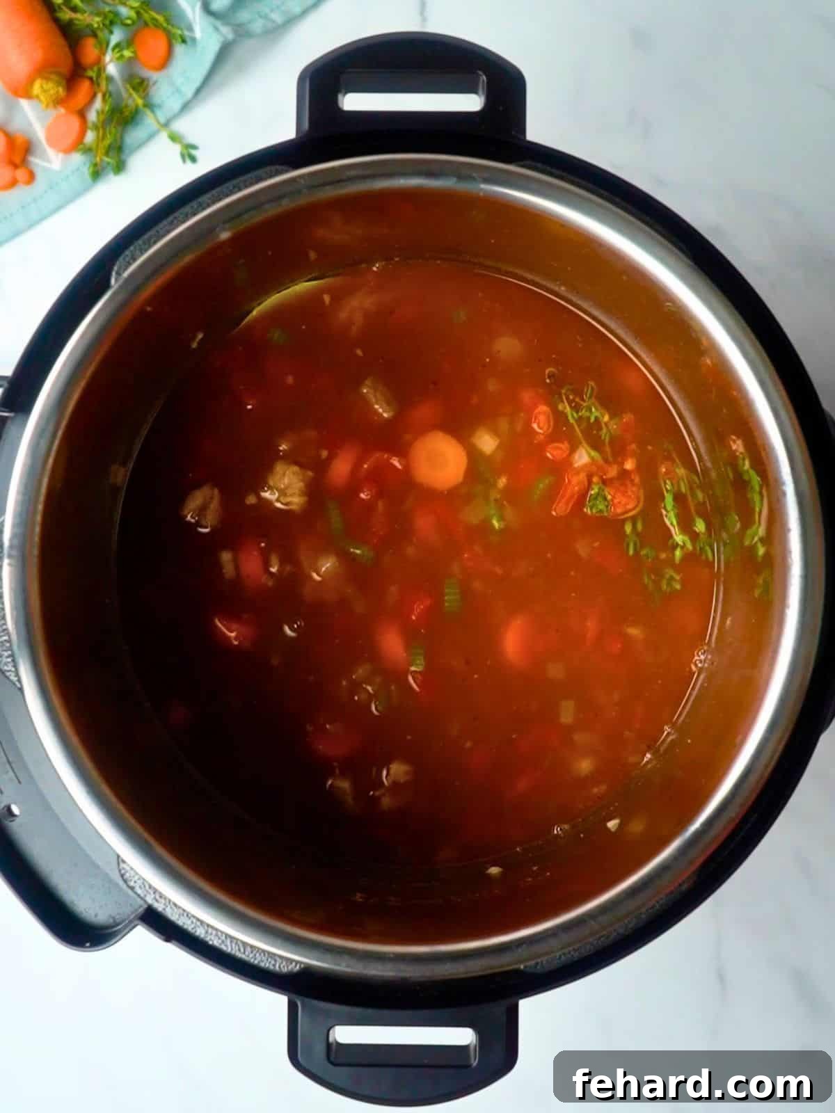 All the delicious ingredients for Beef and Barley Soup, including beef, vegetables, broth, and barley, neatly layered inside the Instant Pot before cooking.