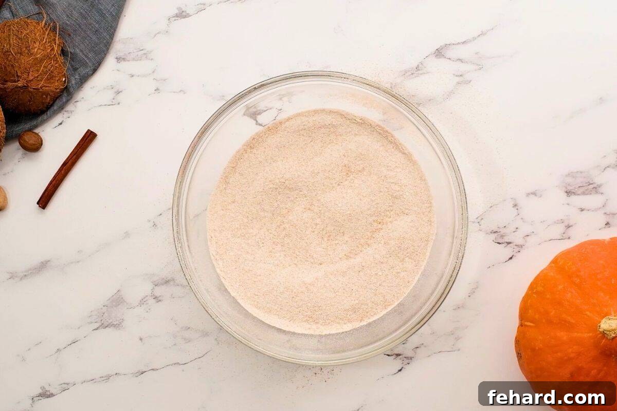 Sifted and whisked whole wheat flour, baking soda, baking powder, salt, and spices together in mixing bowl, ready for wet ingredients.