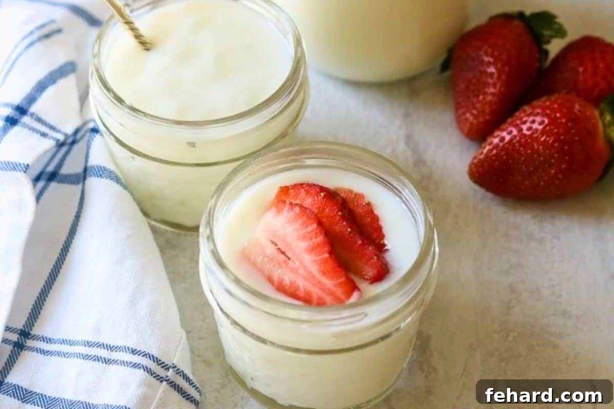 A jar of homemade Instant Pot yogurt topped with fresh strawberries, ready to enjoy.