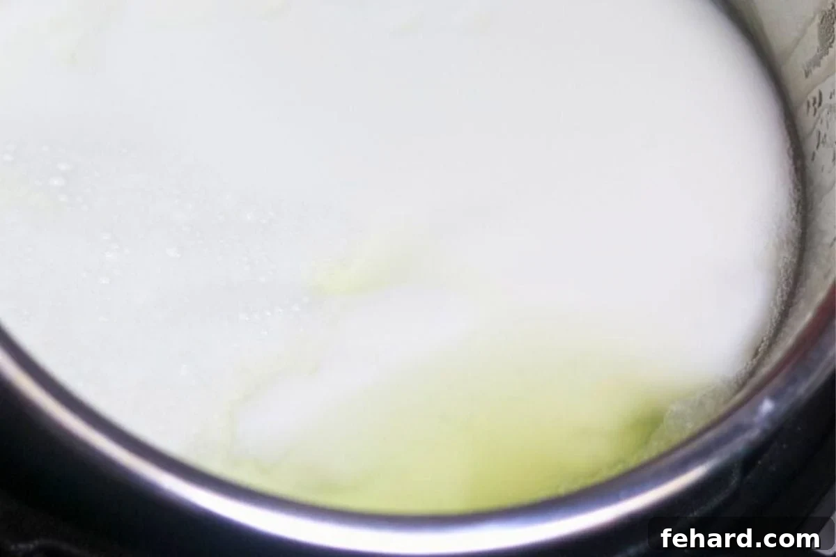 Inner pot of Instant Pot yogurt tilted to show separated whey on the surface.