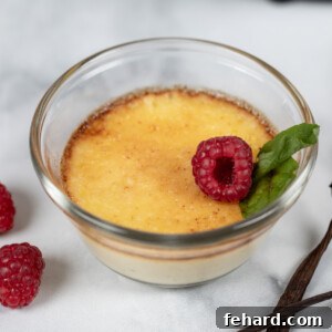 Ramekin with creme brulee topped with fresh raspberries and mint.