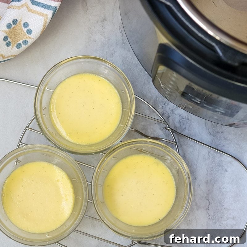 Cooling and chilling your Instant Pot Creme Brulee for the ideal set and texture. Three perfectly cooked custard cups, uncovered and resting on a metal trivet, cooling down after being removed from the Instant Pot.