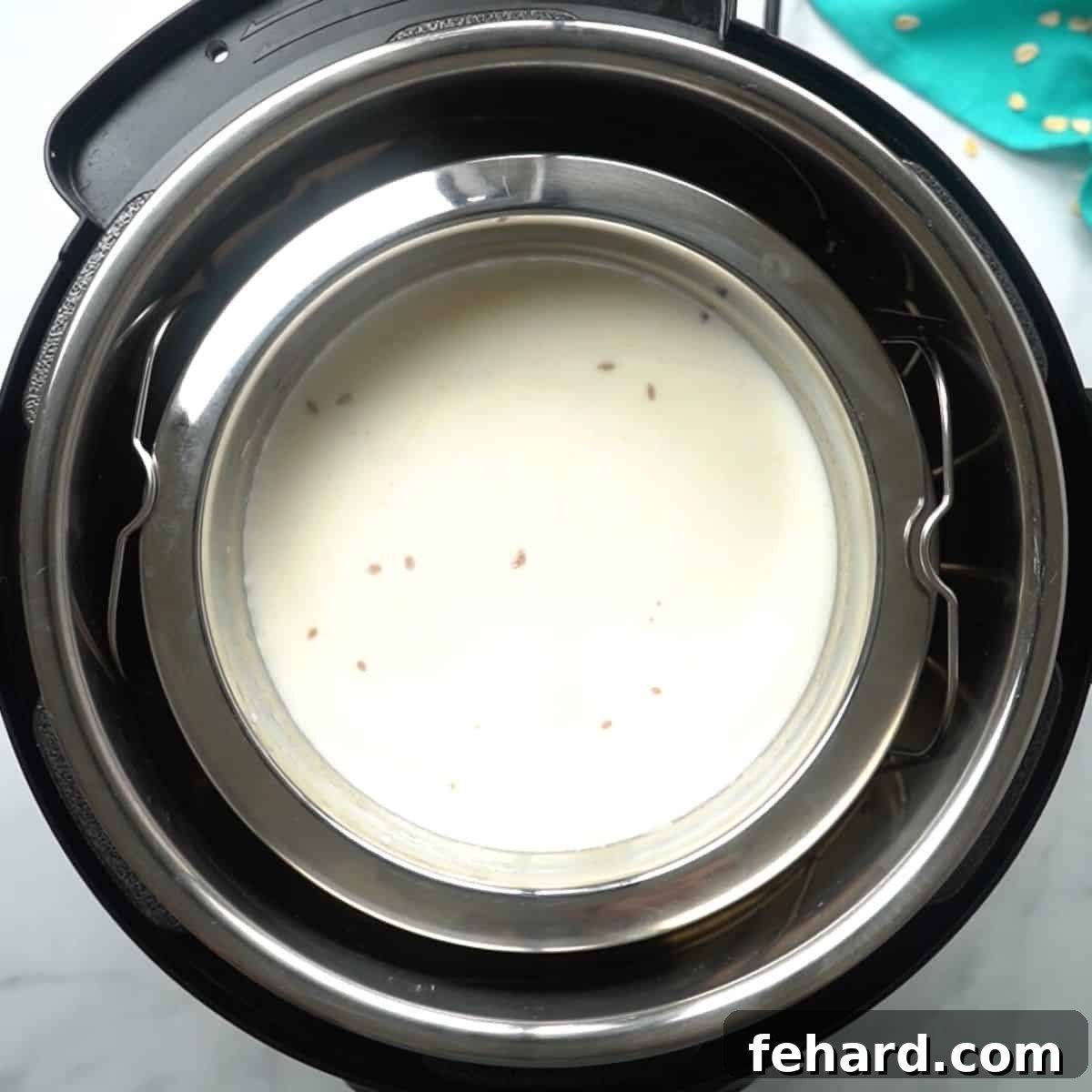 Stainless steel bowl with milk and oats inside inner pot of instant pot, illustrating the pot-in-pot method.