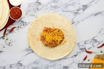 Refried beans and cheese spread on a flour tortilla.