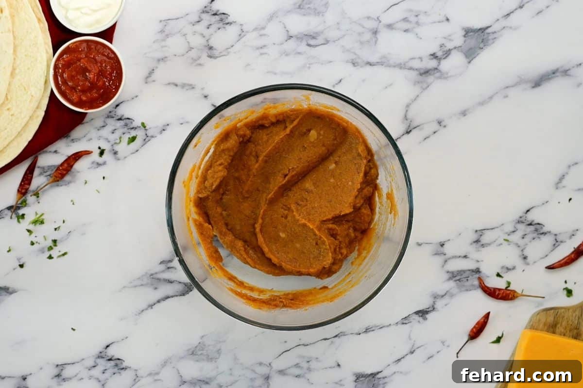 Best Bean Burritos Recipe A bowl showcasing the mixed filling of pumpkin puree, refried beans, and taco seasoning, ready for assembly.