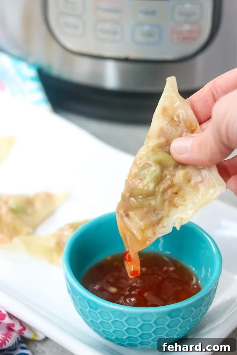 Speedy Instant Pot Veggie Potstickers 2 Potsticker being dipped into blue bowl of homemade sweet chili sauce