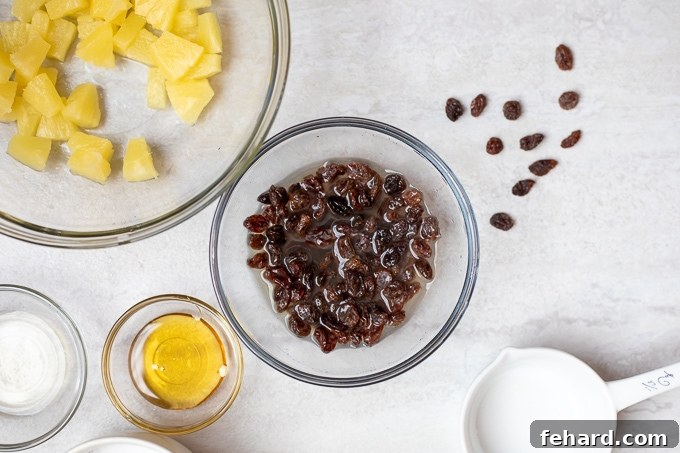 Raisins soaking in pineapple juice, plumping up to enhance their flavor and texture for the salad.