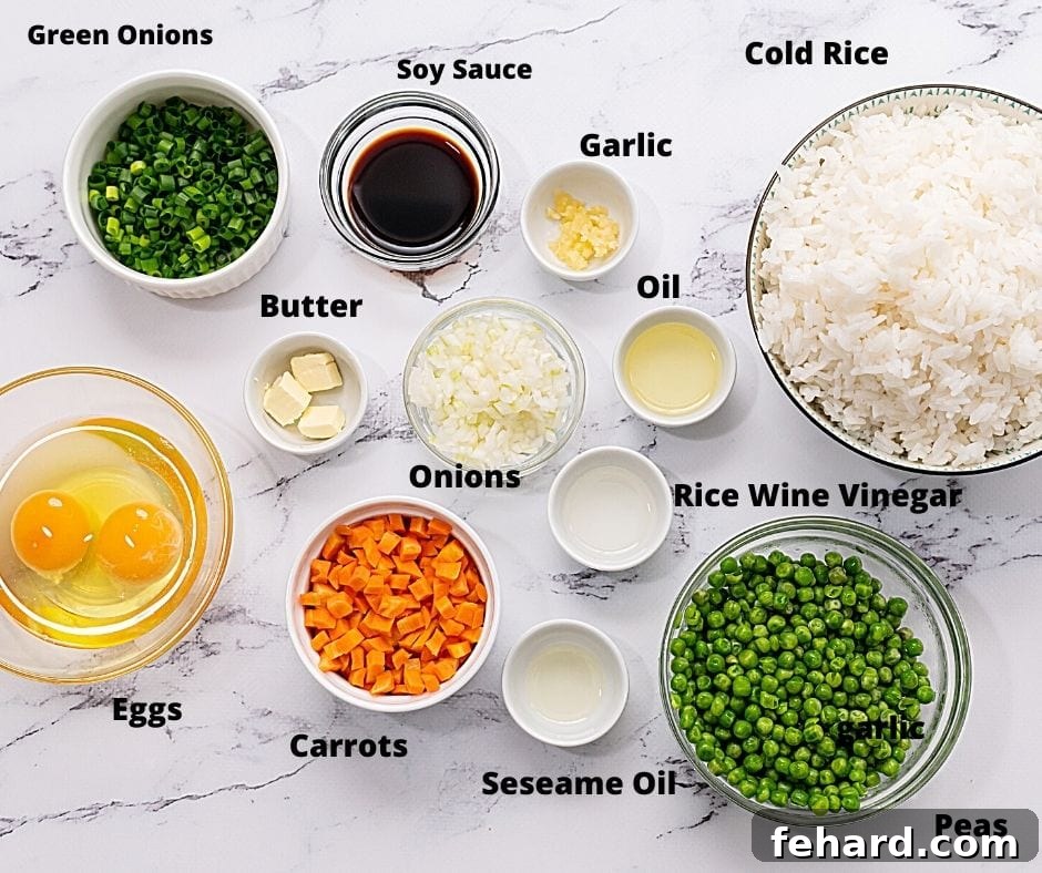 Fresh ingredients laid out for making fried rice on a white countertop: rice, eggs, various vegetables, and seasonings.