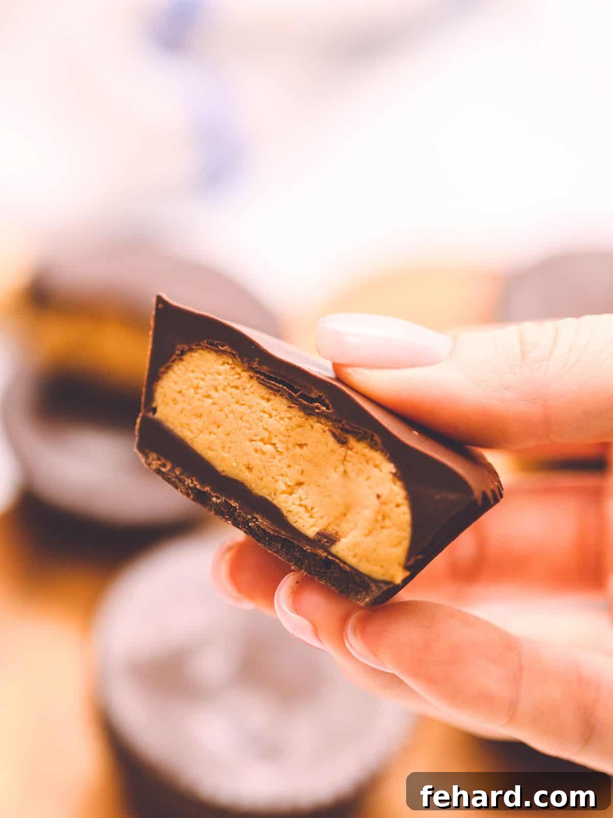 Homemade peanut butter cup cut in half to show layers of chocolate with peanut butter center. Perfect for demonstrating the creamy filling and thick chocolate coating.